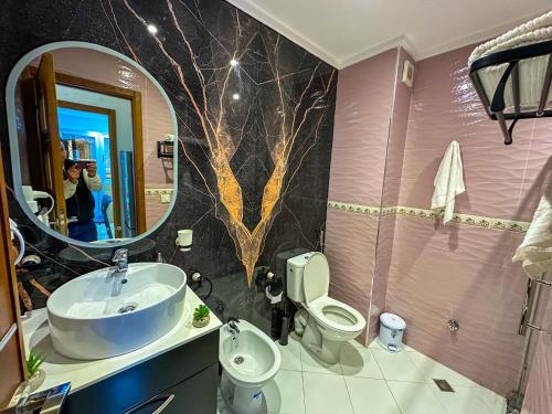 a bathroom with a sink and a toilet and a mirror at Elite Holiday Home - Luxury & Centric Flat in Tangier