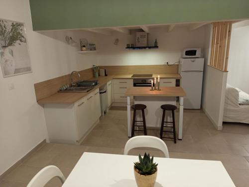 - une petite cuisine avec une table et un comptoir dans l'établissement Appartement théâtre antique, à Orange