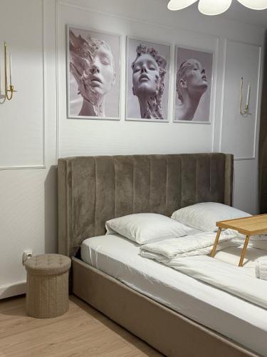 a bedroom with a bed with four pictures on the wall at HomeyHome Strasbourg in Schiltigheim