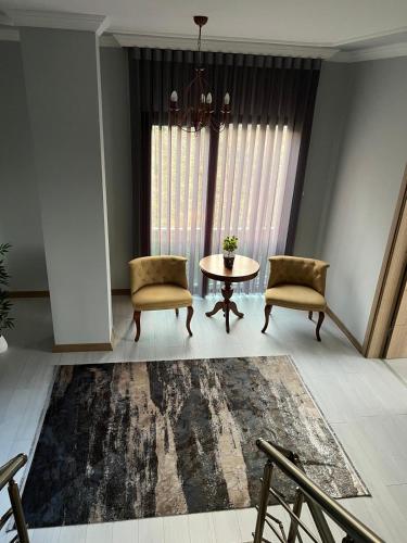 a living room with a table and two chairs and a rug at Çolakoglu konagı in Cayeli