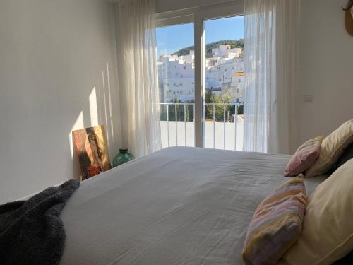 a bedroom with a large bed with a large window at Alojamiento Armenia Patio in Alcalá de los Gazules