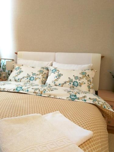 a bed with blue and white sheets and pillows at HELIOS ApArt Hotel - DeLuxe Residence, close to the city CENTER in Timişoara
