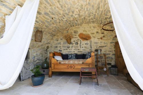 une chambre avec un lit dans un mur de pierre dans l'établissement La Gourmandine -Gîtes, à Courry