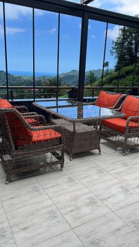 a patio with wicker chairs and a view of the water at Çolakoglu konagı in Cayeli