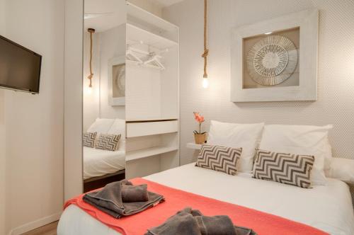 1 dormitorio con cama blanca y manta roja en Apartamentos Uncibay Premium, en Málaga