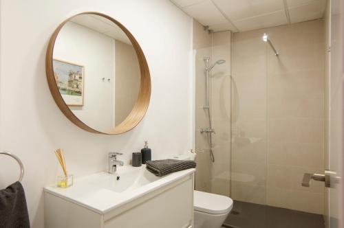 y baño con lavabo, espejo y aseo. en Apartamentos Uncibay Premium, en Málaga