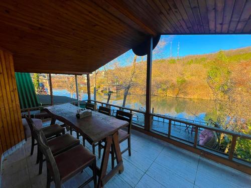 a table and chairs on a porch with a view of a lake at Paradise Plus Ağva in Agva
