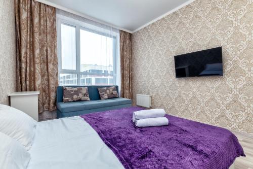 ein Schlafzimmer mit einem großen Bett mit einem lila Teppich in der Unterkunft Уютная квартира на левом берегу in Astana