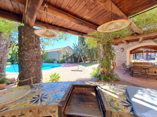 an outdoor patio with a table and a pool at Dimora Migliori in Viagrande