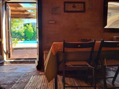a table and chairs in a room with an open door at Dimora Migliori in Viagrande