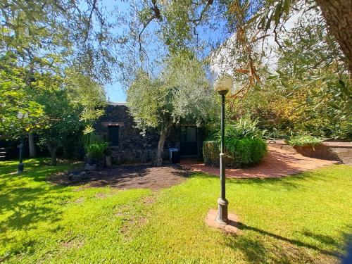 a lamp post in the grass in front of a house at Dimora Migliori in Viagrande