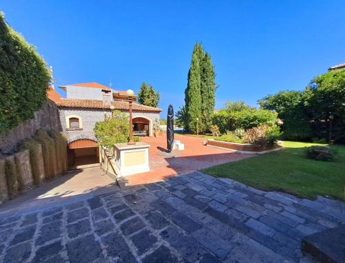 a house with a stone walkway in a yard at Dimora Migliori in Viagrande