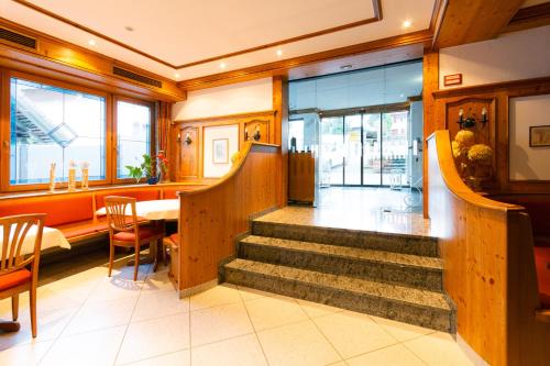 a restaurant with stairs and a table and chairs at Hotel Grünwinkel in Oberharmersbach
