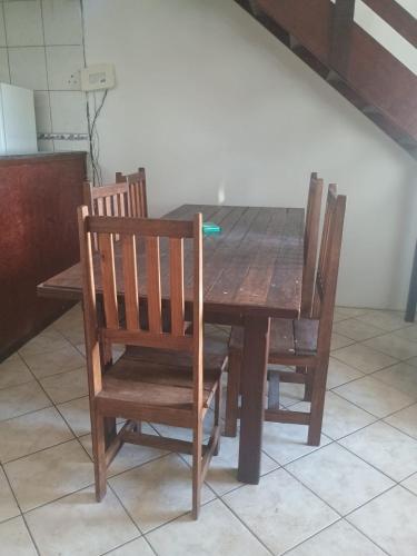 a wooden dining room table with four wooden chairs at Casa em Arembepe in Camaçari