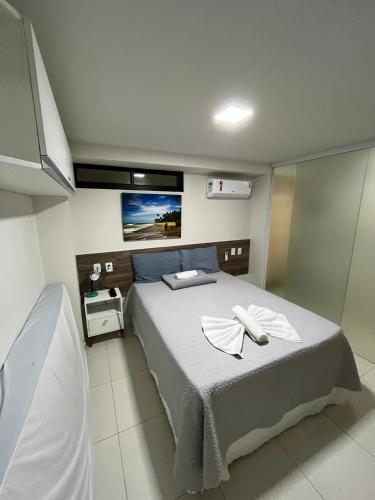 a bedroom with a bed and a tv on the wall at Flat do BZ - 2 quartos- Praia de Tabatinga- Conde in Conde