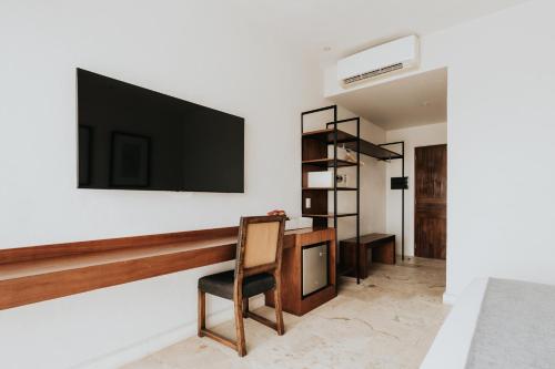 a living room with a television on a wall at The Strabon Tulum in Tulum