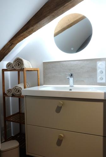 une salle de bain avec un lavabo et un miroir dans l'établissement La Citadelle Endormie à Ombrée d'Anjou, à Pouancé