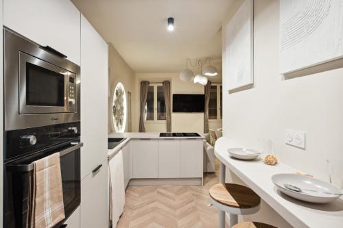 - une cuisine avec des placards blancs et un comptoir avec un évier dans l'établissement Cosy moon for 4 or 6 people quartier du Port, à Nice