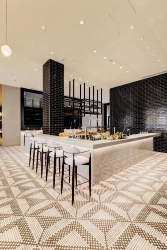 a kitchen with a bar with stools in a room at Cinnamon Life at City of Dreams in Colombo