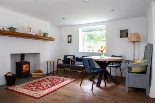 a living room with a table and a fireplace at Croan Cottage in Mayobridge