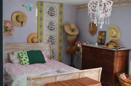 - une chambre avec un lit et des chapeaux sur le mur dans l'établissement Maison charmante à Cadillac, à Cadillac