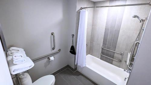 a bathroom with a shower and a toilet and a sink at Best Western Premier Hotel at Fisher's Landing in Vancouver