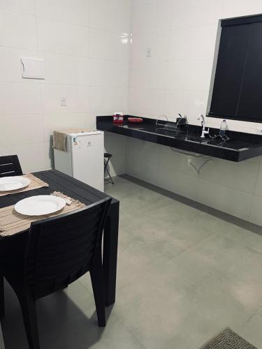 a room with a table and a tv on a wall at Pousada frente Hecad e leilomaster in Goiânia