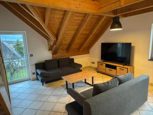 a living room with two couches and a tv at 5-Seen-Loft mit 4-6 Schlafplätzen, Ferienwohnung Nähe Ammersee, neu eingerichtet in Kottgeisering