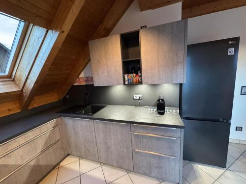 a kitchen with a sink and a refrigerator at 5-Seen-Loft mit 4-6 Schlafplätzen, Ferienwohnung Nähe Ammersee, neu eingerichtet in Kottgeisering