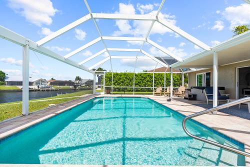 a swimming pool with a pergola and an outdoor swimming poolvisor at Cozy Cape Cottage Gulf Access in Waterway Estates