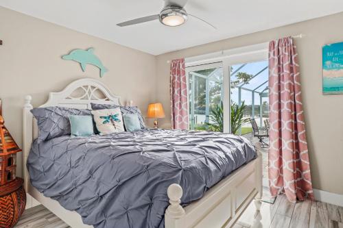 a bedroom with a bed and a window with a dolphin on it at Cozy Cape Cottage Gulf Access in Waterway Estates