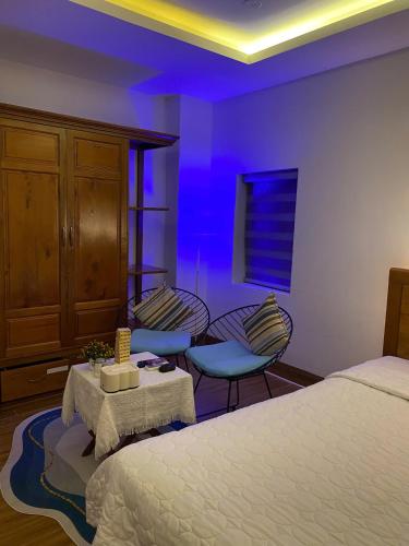 a bedroom with a bed and two chairs and a table at Sea Star Hotel Quy Nhon in Quy Nhon
