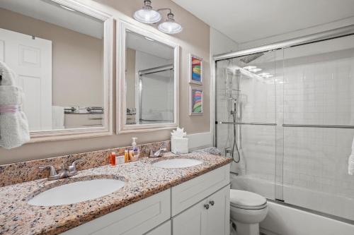 a bathroom with two sinks and a shower at Cozy Cape Cottage Gulf Access in Waterway Estates