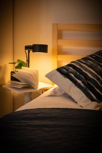 - une chambre avec un lit avec une lampe et un livre dans l'établissement La note bleue, à Saverne