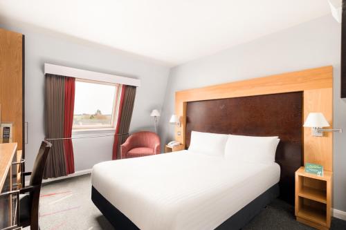 a hotel room with a bed and a window at Holiday Inn Aberdeen West by IHG in Westhill 