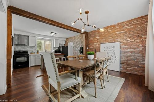 a kitchen and dining room with a brick wall at 4 Bedroom Luxury House, Free Parking, Next to LRT, Kitchener Downtown, near Chicopee Ski Club in Kitchener