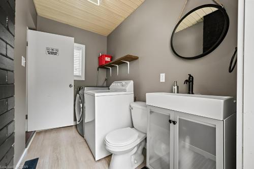 a bathroom with a toilet and a sink and a mirror at 4 Bedroom Luxury House, Free Parking, Next to LRT, Kitchener Downtown, near Chicopee Ski Club in Kitchener