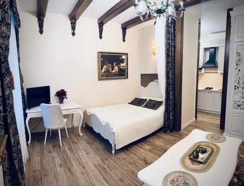 a bedroom with a bed and a desk and a table at Noble Apartments in Vilnius