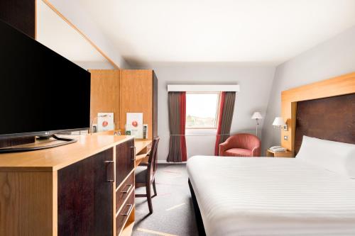 a hotel room with a bed and a flat screen tv at Holiday Inn Aberdeen West by IHG in Westhill 