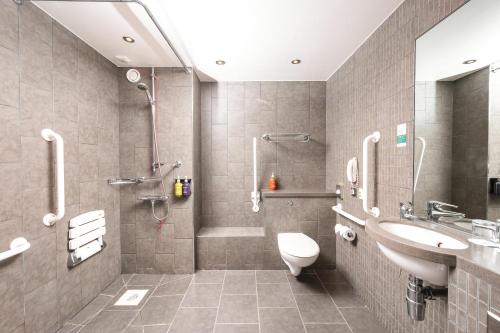 a bathroom with a shower and a toilet and a sink at Holiday Inn Aberdeen West by IHG in Westhill 