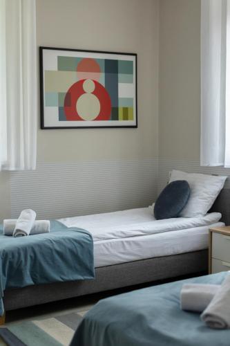 a bedroom with two beds and a picture on the wall at Apartamenty Wczasowa - z widokiem na góry, parkingiem, rowerownią in Kudowa-Zdrój