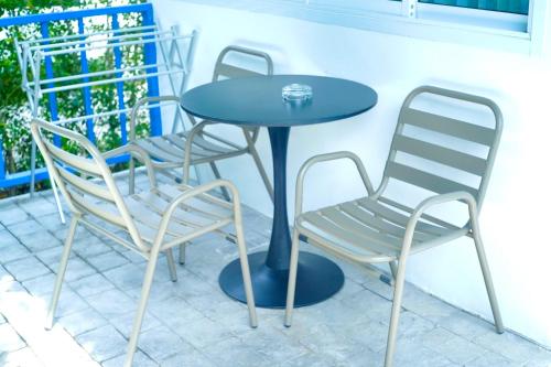 two chairs and a blue table and chairs on a patio at Three Trees Samui Resort - Sarocha Villa in Lamai