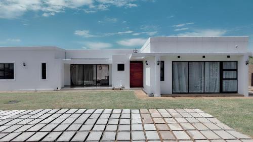 a white house with a red door at Tubungu Estate 217 in Matsapha