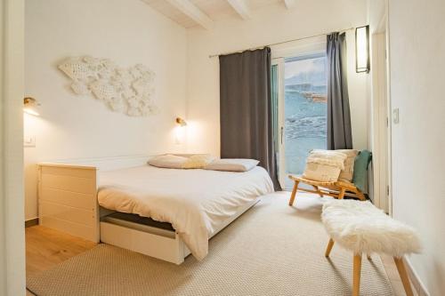 een witte slaapkamer met een bed en een raam bij Apartment Mare di Spartaia in Procchio