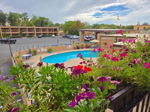 a view of a resort with a pool and flowers at El Sendero Inn, an Ascend Collection Hotel in Santa Fe