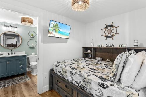 a bedroom with a bed and a sink and a mirror at Sunrise Surprise 9th floor 2BR 2 BA King Suite Beach shuttle, heated pool! in Destin