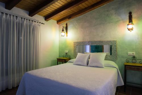 a bedroom with a white bed and a mirror at Placer de Meca in Zahora