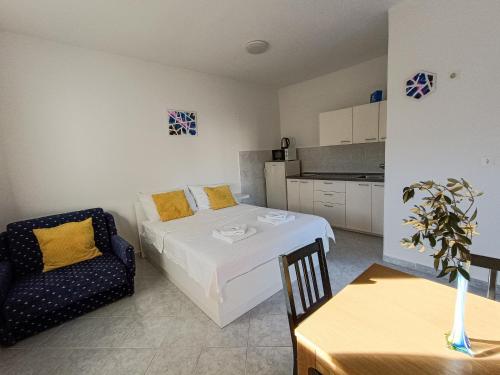 a bedroom with a bed and a chair and a table at Apartments Frank in Šilo