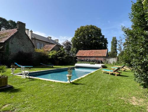 une cour avec une piscine dans la cour dans l'établissement Le Jardin secret du Dr Papertian, à Saint-Clair-sur-lʼElle