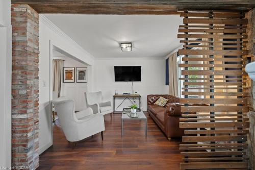 a living room with a couch and a tv at 4 Bedroom Luxury House, Free Parking, Next to LRT, Kitchener Downtown, near Chicopee Ski Club in Kitchener